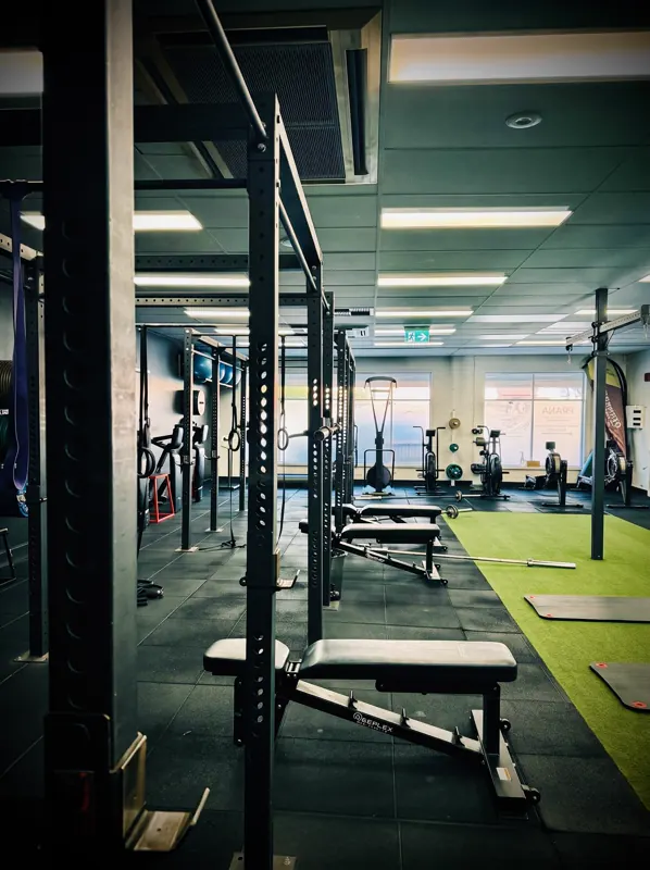Squat rack and benches beside the turf