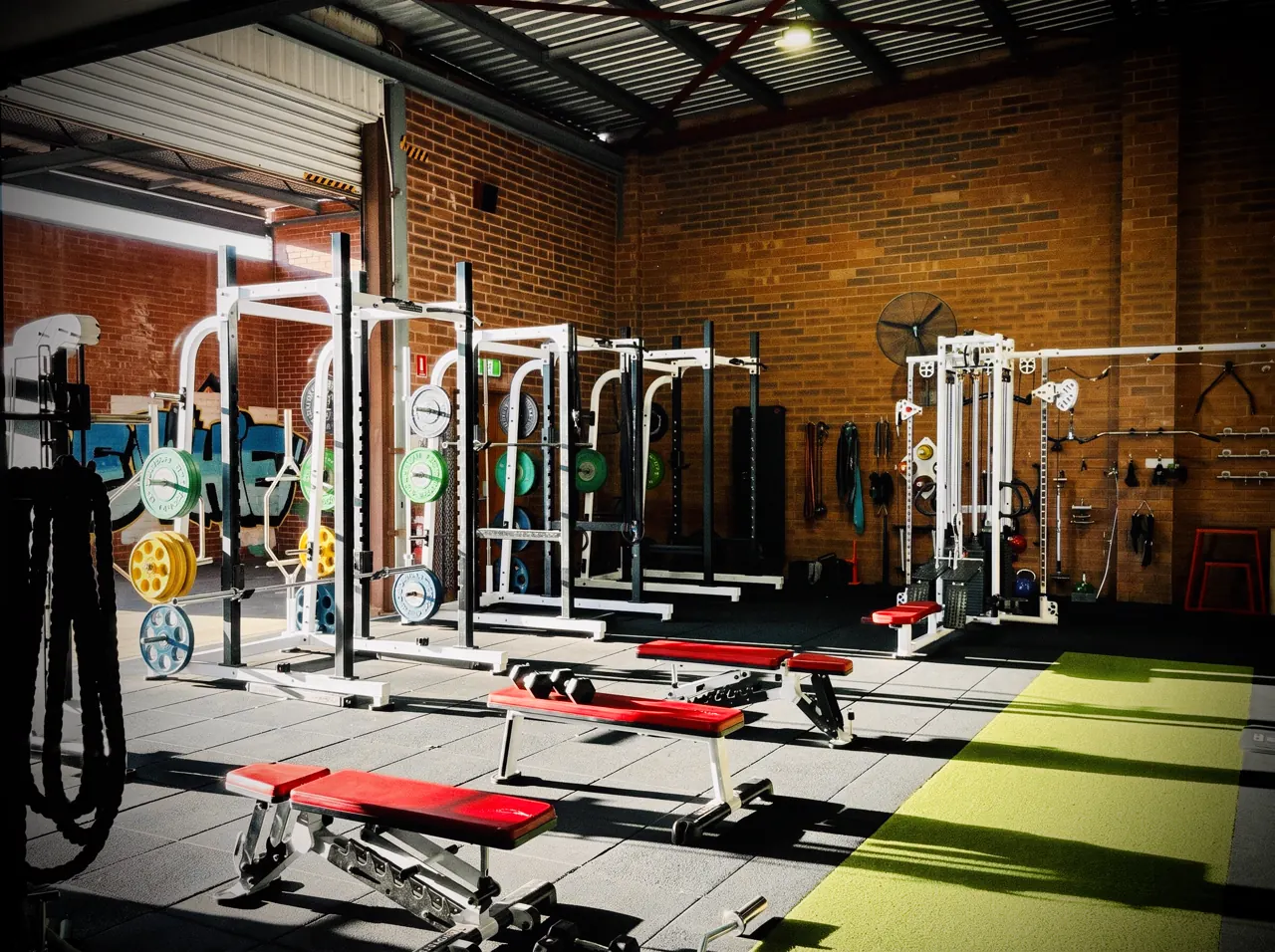 Squat racks and benches in the Tribe strength room